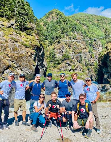 Group posing in front of a rugged mountain landscape.