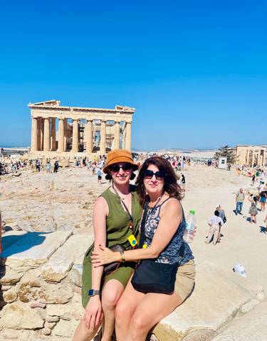 Two women posing with the Acropolis in the background.