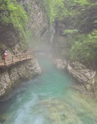Wooden walkway over a turquoise river in a gorge.