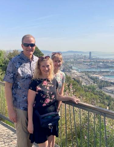 Couple posing with a panoramic view of a seaside city.