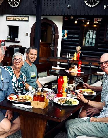 Group of people enjoying a meal outdoors at a restaurant.