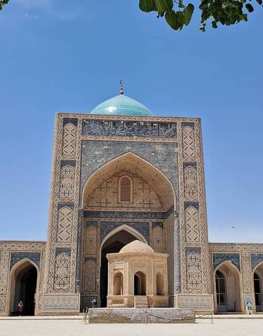 Close-up of an ornate mosque entrance with a blue dome.