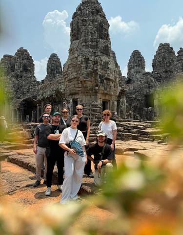 Small group in front of a detailed temple ruin.