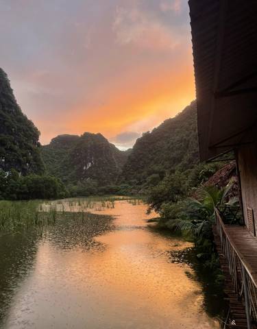 Sunset over a mountainous landscape with a serene lake.
