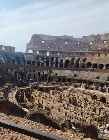 Interior view of the Colosseum filled with tourists.