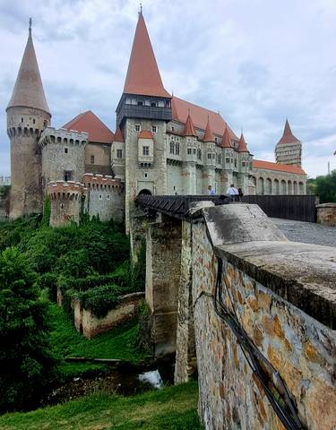 Large medieval fortress with towers and a bridge.