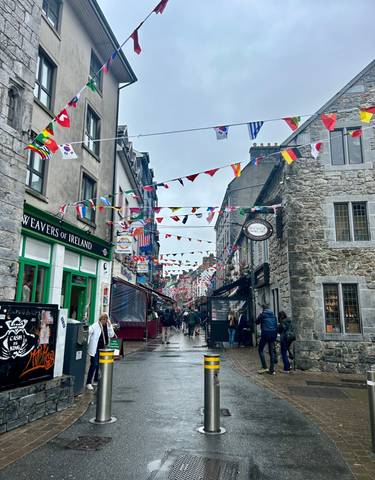 Busy street with flags and people.