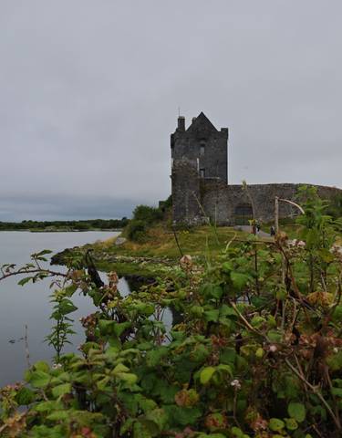 A historic stone tower by a lake.