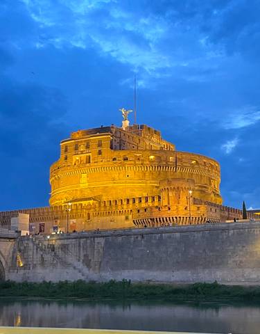 A night view of Castel Sant'Angelo illuminated by lights.