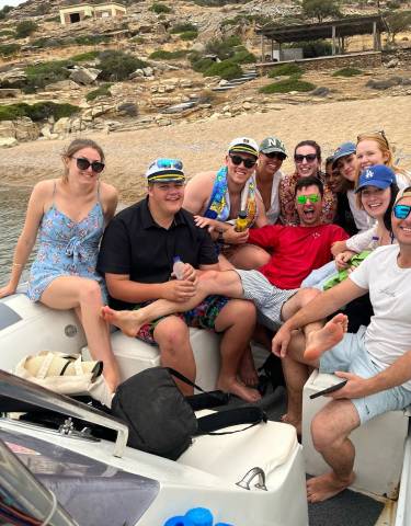 Group on a boat, smiling and having drinks.