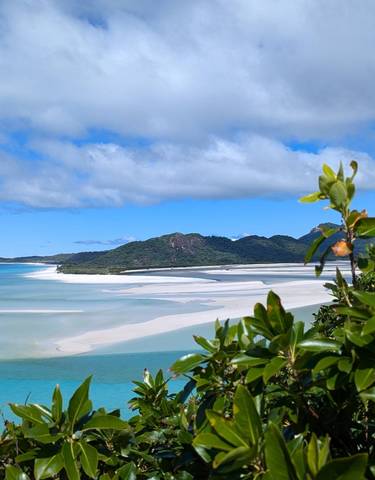 View of a beach with white sand and blue waters.