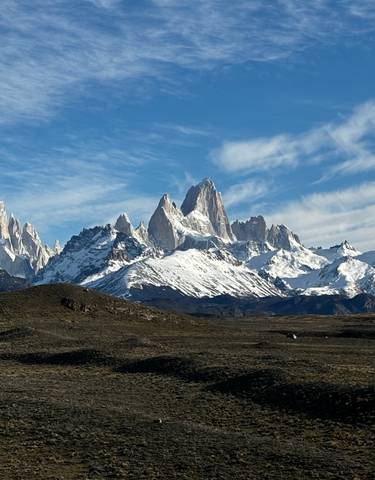 Snowy mountain range under a blue sky.