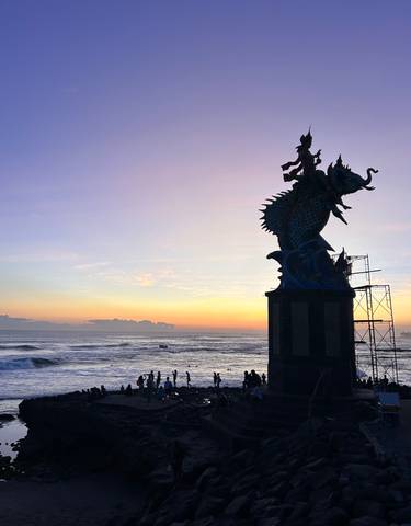 Sunset by a seashore statue