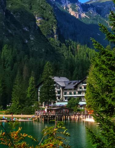 A large building surrounded by lush green forested hills.