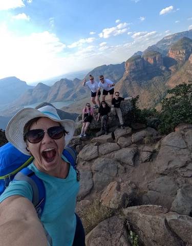 Hikers posing on a rocky cliff with a breathtaking canyon view.