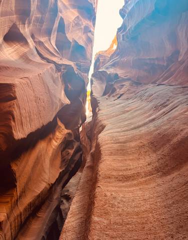 Beautifully lit canyon with towering rock walls.