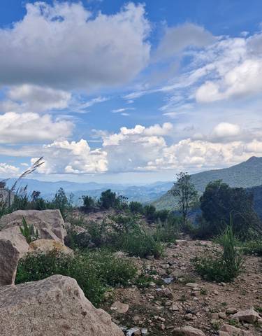 Mountain landscape with clouds and patches of blue sky.