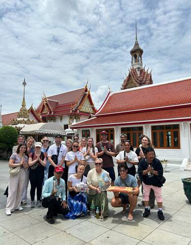 Group posing in front of a traditional temple.