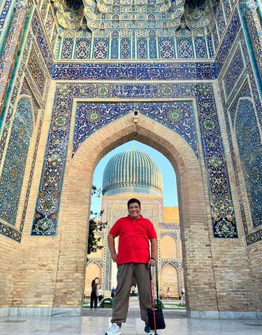 Person standing under a beautifully designed archway.