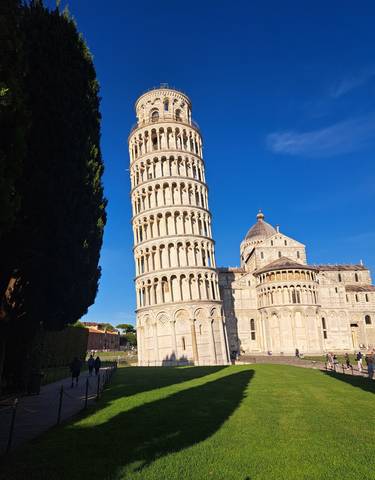 Leaning Tower of Pisa under a clear blue sky.