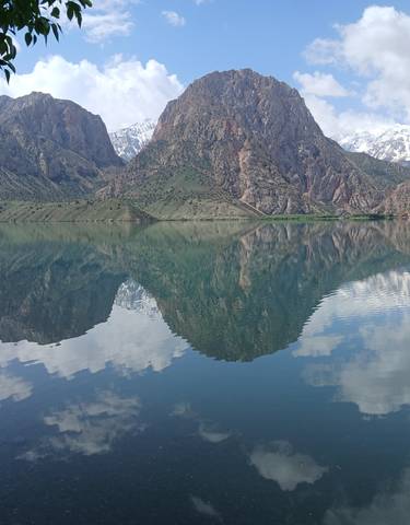 Mountain reflected in a clear lake under a blue sky.