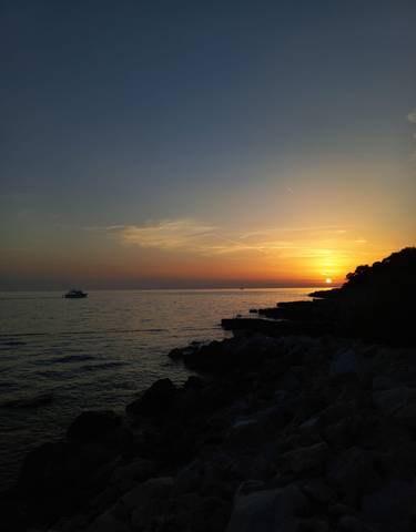 Sunset over the sea with a boat.