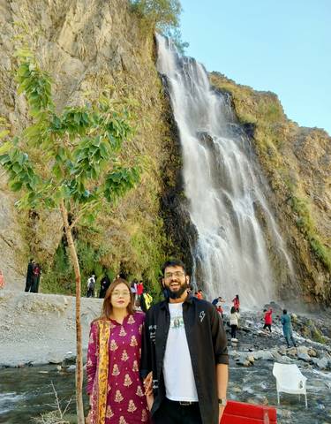 A group of people enjoying a waterfall backdrop.