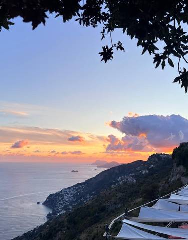 Sunset over a coastal landscape with calm sea.