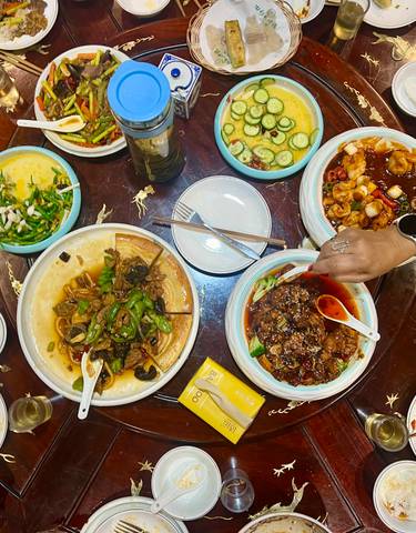 A table filled with various dishes and people dining.