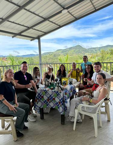 Group of people enjoying a coffee tasting with a scenic background.