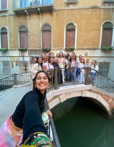 Group of friends posing on a bridge over a canal.