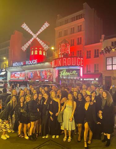 Group photo outside the Moulin Rouge in Paris at night