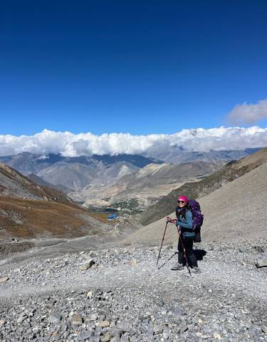 Hiker with trekking poles in a mountainous landscape