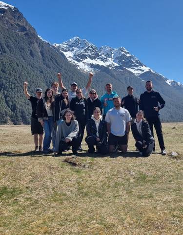 Group of people celebrating with a scenic mountain view.