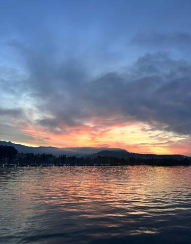 A stunning sunset over mountains and water.
