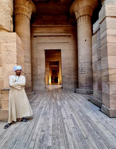 Man in traditional attire in a historical building.