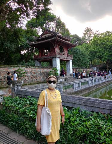 Visitor wearing a mask standing in front of a historic gate