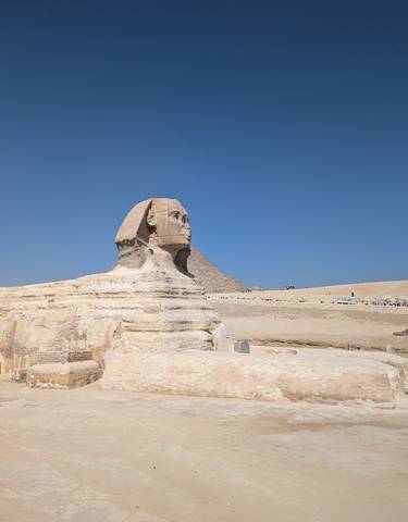 The Sphinx and pyramids under a bright sky.