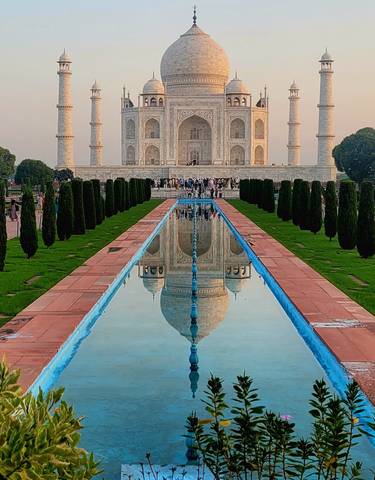 Reflection of the Taj Mahal in a long fountain pool.