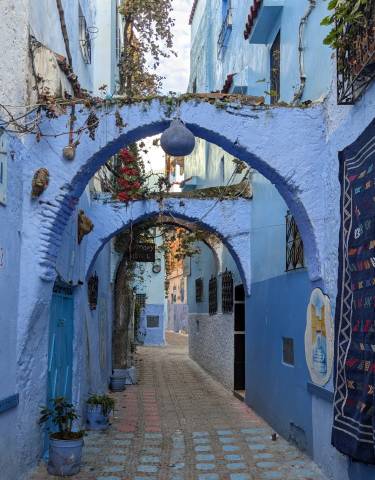Narrow alleyway in a blue-painted medina.