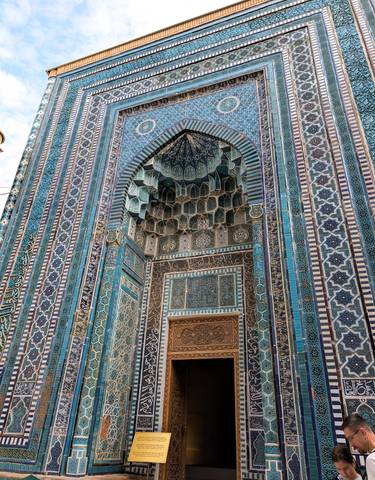 Intricate blue-tiled facade of an ancient building.