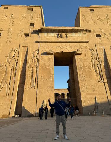 Front view of an ancient temple with carvings and a person.