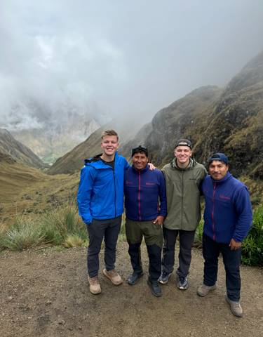 Group of hikers posing in a picturesque mountainous landscape.