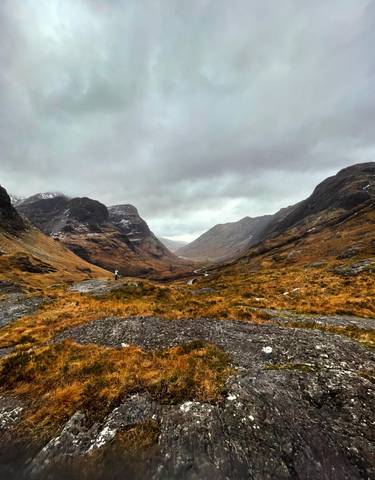Wide valley view with mountains and a river.