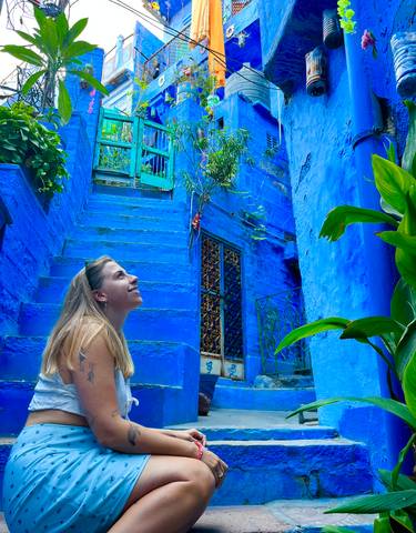 Woman smiling in a blue-painted alley