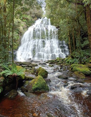 Waterfall cascading over rocks in a forest setting.