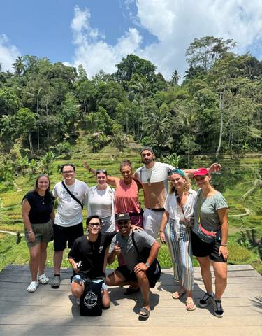 Group of people posing in front of rice terraces.