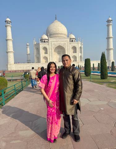 Couple standing in front of the Taj Mahal.