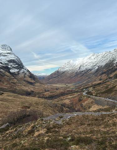 Majestic snow-capped mountains surrounding a valley under a clear sky.