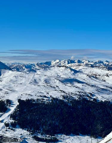 Snow-covered mountains under a blue sky.